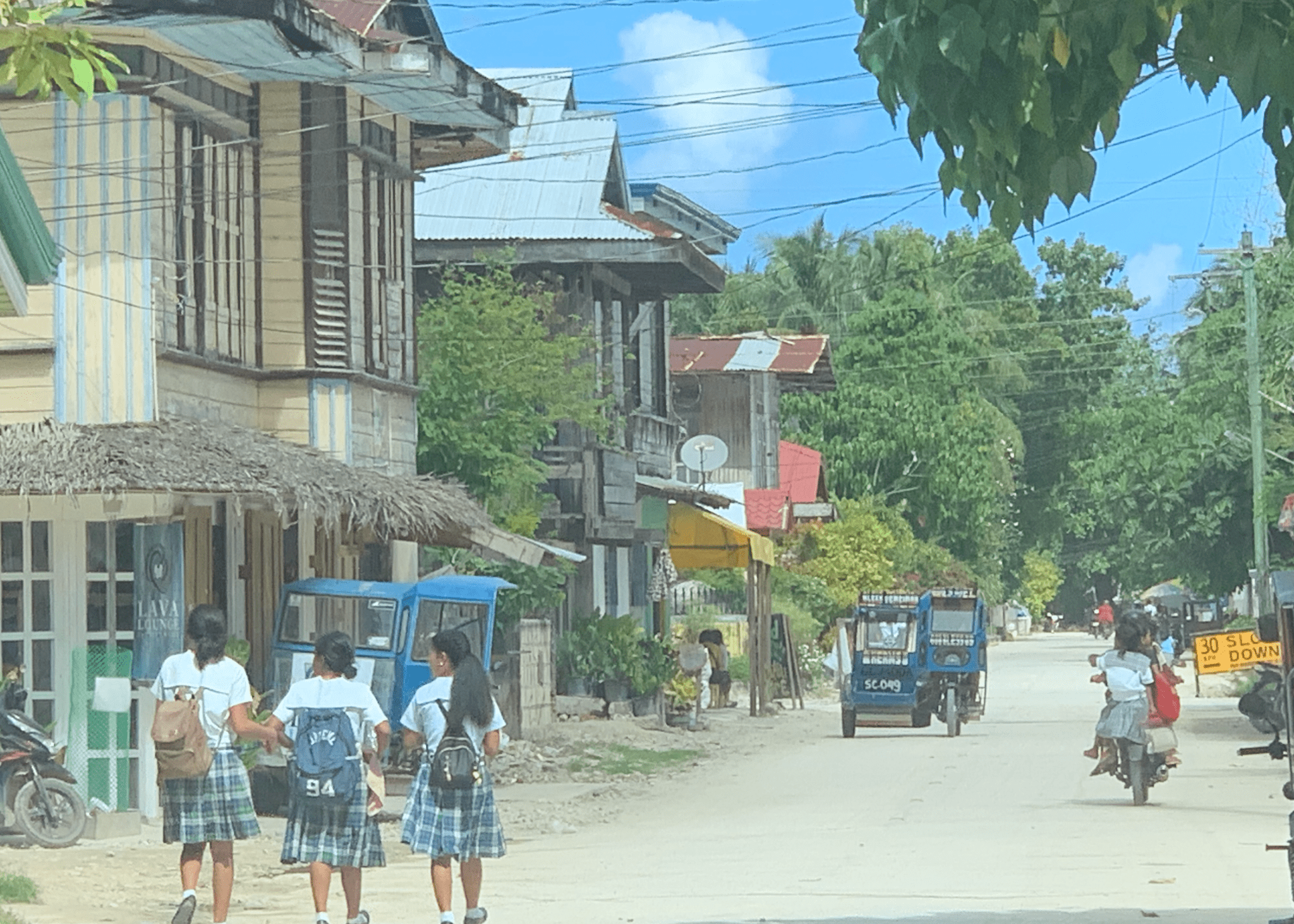 シャルガオ島ジェネラル・ルナの日常の街並み。制服姿の地元の学生とトライシクルが行き交うローカルな風景