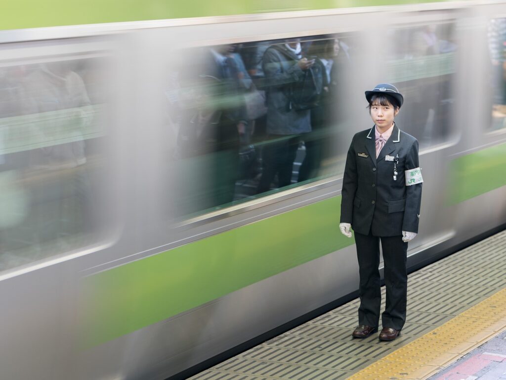 山手線の駅のホームから電車が出発する様子