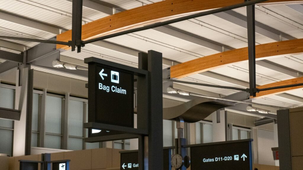 空港の案内表示。左矢印とカバンのアイコン、Bag Claim(手荷物受取所)の文字