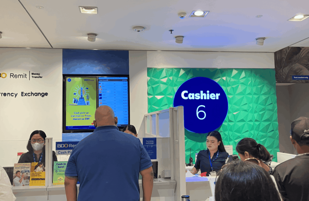セブ島の施設内にある「BDO Remit」両替カウンター（Cashier 6）と並んでいる人々