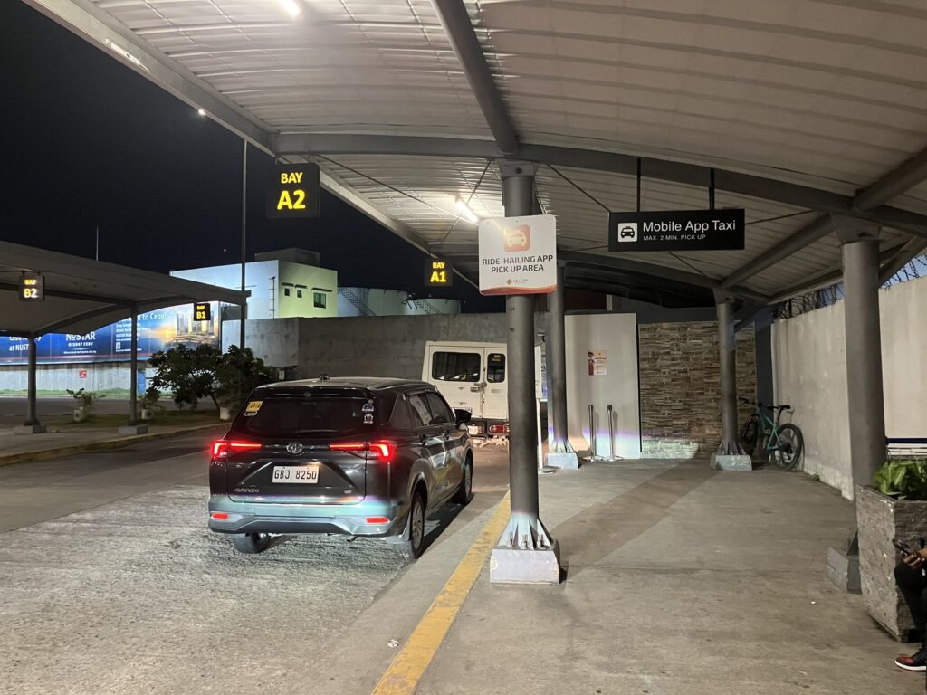 マクタン・セブ空港の配車アプリ乗り場。BAY A1・A2の電光表示と「RIDE-HAILING APP PICK UP AREA」の案内板